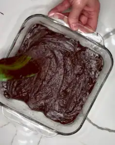 spreading brownie mixture in pan